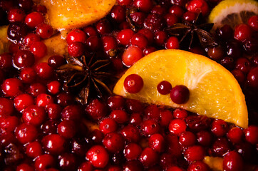 metal pot on the stove. Oranges and cranberries in mulled wine
