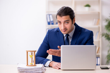 Young male employee in time management concept