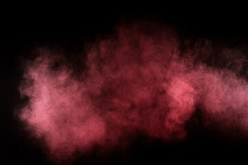 Red and pink powder explosion on black background. Colored powder cloud. Colorful dust explode. Paint Holi.