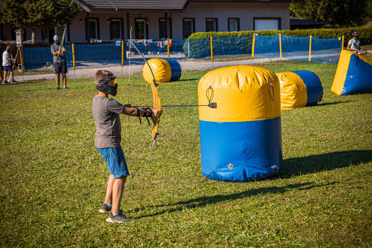 Teenage boy playing archery tag on a meadow