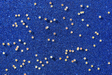 Background of gold stars on colored paper with sequins