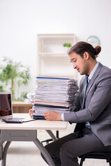 Fototapeta premium Young male businessman unhappy with excessive work