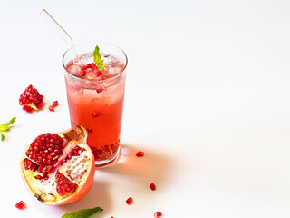 Pomegranate juice on a white background in glass glasses with glass straws.