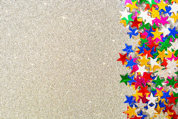 Background of multicolored stars on multicolored paper with sequins