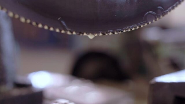 Lubricant dropping from a circular saw, slowmotion