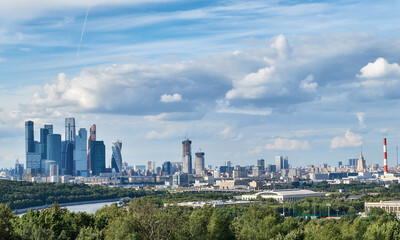 Fototapeta premium Skyscrapers with river reflections under cloudy sky in Moscow city district