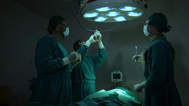 The surgeon is working in a hospital operating room.
