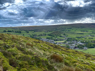 Fototapeta na wymiar Landscape view, from Haworth moor, with thunder clouds, gorse, hills, and villages near Haworth, Bradford, UK