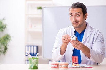 Young male dentist working in the clinic