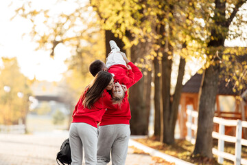 father, mother and little daughter are walking in the autumn park, happy family is having fun outdoors. father's, mother's and baby's day