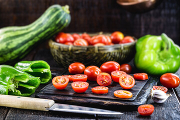 sliced ​​red tomato to be used as a culinary ingredient on rustic wooden cutting board, vegan and organic cuisine