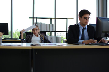 Business people sitting at desk and working with laptop computer.