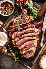 Slices of juicy beef steak fork knife spices salt pepper herbs and draft beer