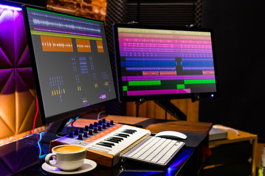cup of coffee on desk with dual display monitor and midi keyboard for music production