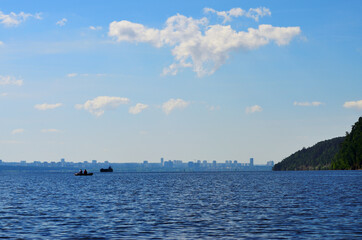 fishermen on a boat in the middle of the river against the silhouette of the city