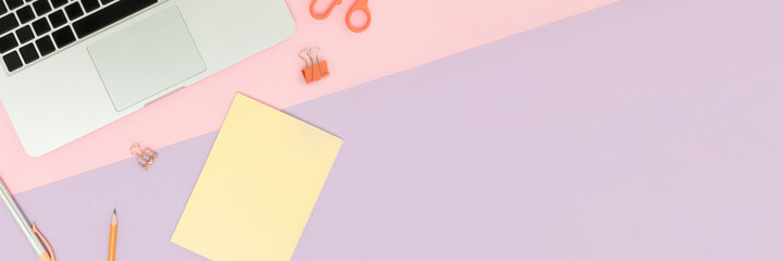 Workspace banner with laptop and cute stationery on a colorful background. E-learning concept with...