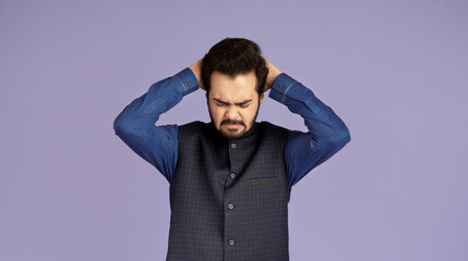 Negative emotions. Desperate Indian guy plucking his hair on lilac background