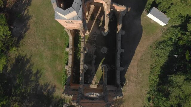 Beautiful top down rising aerial shot of birds flying over Araca church in Serbia near Novi Becej.