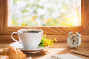 Coffee and flower for breakfast placed by the window with morning sunlight