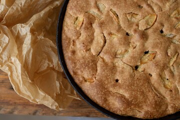 apple pie in a frying pan on a wooden background