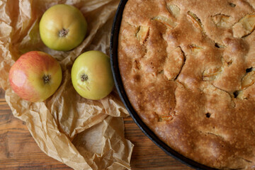 apple pie in a frying pan on a wooden background
