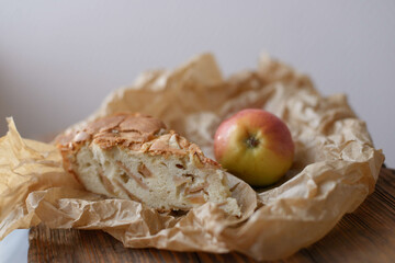 a slice of apple pie in a frying pan on a wooden background