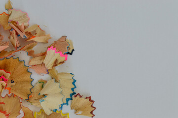 wood shavings from colored pencils on white background copy space