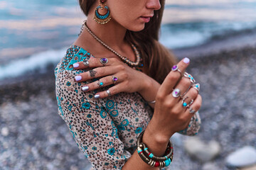 Bohemian chic gypsy woman with manicure wearing jewelry accessories and dress. Boho detail close up