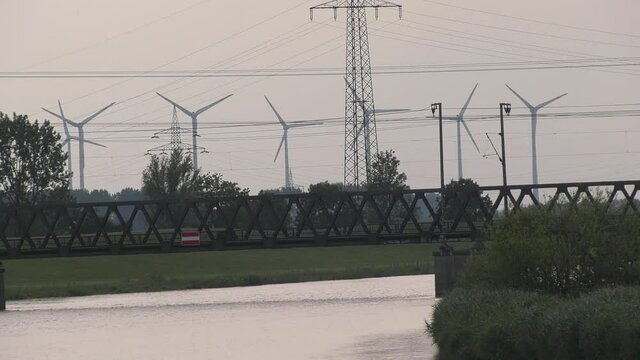 Windr&auml;der nahe der Stadt Leer in Ostfriesland mit dem Fluss Leda im Vordergrund