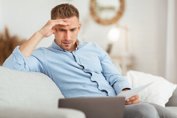 Portrait of man sitting on couch using pc