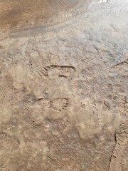 two footprints on wet river sand