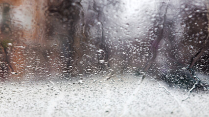 Drops Of Rain On Glass Background. Street Bokeh Lights Out Of Focus. Abstract Backdrop