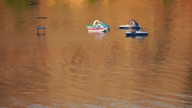 Pedal boats in the lagoon in the golden water in the morning at sunrise