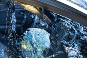 Burnt-out passenger car. Burnt car interior close-up. Fire in the car. Danger.