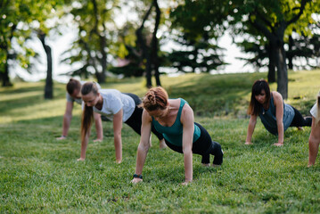 A group of people do yoga in the Park at sunset. Healthy lifestyle, meditation and Wellness