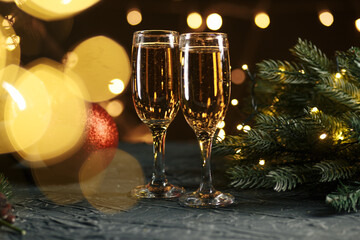 Ribbon, baubles and wine against Christmas lights.