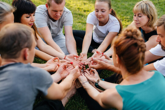 A group of people do yoga in a circle in the open air during sunset. Healthy lifestyle, meditation and Wellness