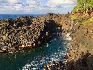 Cliffs along the coast of Hawaii with waves crashing in