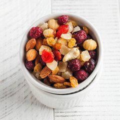 A mix of nuts and candied fruits on a white wooden table. Healthy snack, healthy dessert.
