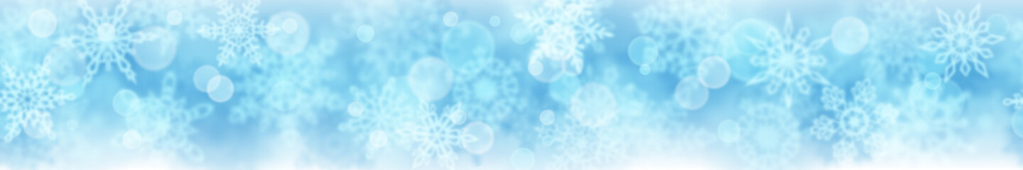 Christmas banner of blurry snowflakes on light blue background