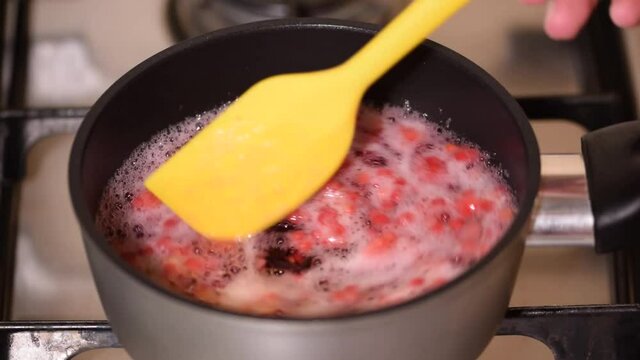 Pot with compote of fresh berries on stove.