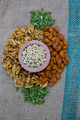 Pine with mixed nuts on a brown texture textile slate surface