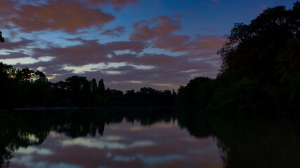 Sky, clouds, trees and lake during a warm summer sunset