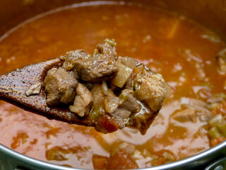 Goulash pork and beef meat on wooden spoon