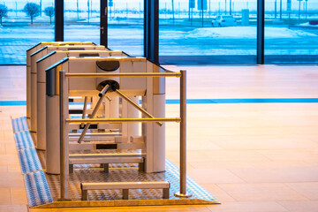 Turnstiles in a spacious building. Access system in an office building. Control of access to premises. Security system in the room. The entrance to the office through the turnstiles.