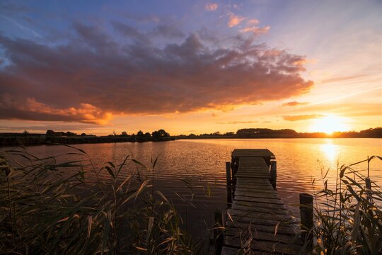 scenic lakseide view with jetty and colorful clouds