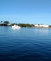 Naklejka na ściany i meble Boat on Harbor with Blue water and blue sky