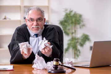 Old male judge working in courthouse