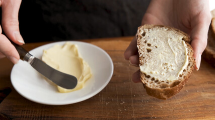 Bread and butter. Smearing butter on sourdough bread