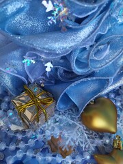 Beautiful blue background for a christmas card with gilged gold toys on the christmas tree